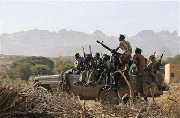 Fighters of the Sudan Liberation Army (SLA) sit on top of a truck outside the north Darfur town of Kutum, December 15, 2007. (Reuters)