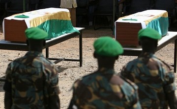 FILE - A handout picture from the African Union Mission in the Sudan shows AMIS soldiers standing in front of coffins of killed comrades prior a funeral service for seven Nigerian Protection Force peacekeepers and 3 military observers from Mali, Senegal and Botswana at the Mission's Forward Headquarters in El-Fasher, North Darfur, 04 October 2007. (STUART PRICE/AFP/Getty Images)