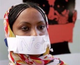A Sudanese journalist covers her mouth with a piece of paper bearing the word 'NO' during a hunger strike held by journalists in Khartoum on November 4. 2009