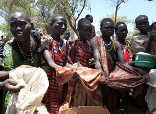 Women from Dadinga tribe carry a box of oil during food distribution by WFP in the village of Lauro, Budy county, in Eastern Equatoria State, south Sudan, April 3, 2010. (Reuters)