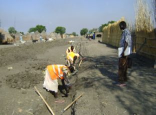 Women in Malakal doing brush clearing and grubbing on road alignment before starting formation of side drains on carriageway (ST)
