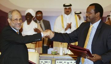 Ghazi Salah Eddin L, adviser to Sudan's President Omar Hassan al-Bashir, shakes hands with Al-Tijani Al-Sissi of the Liberation and Justice Movement (LJM) after signing a ceasefire agreement in Doha March 18, 2010. (Reuters)