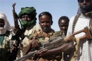 A section leader from the SLA, center, wearing a captured Sudanese officer's uniform with three stars, and other rebels are pictured along the Chad-Sudan border, Feb. 17, 2007 (AFP)