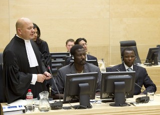 FILE - Karim Khan (L), the lawyer for Abdallah Banda Abakaer Nourain (C) and Saleh Mohammed Jerbo Jamus (R), both suspected of having committed war crimes in Darfur, speaks at the International Criminal Court in The Hague June 17, 2010 (Reuters)