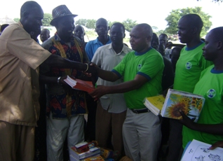 Rumbek branch manager of Kenya Commercial Bank, Roger Mwema (third left), hands out educational materials to parent and teachers in Lakes state, South Sudan, 20, Oct. 2010 (ST)