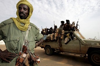 Rebels from the Sudan Liberation Army (SLA), led by Minni Minawi, ride at the back of a pick-up truck in North Darfur capital on 19 September 2008 (AFP)
