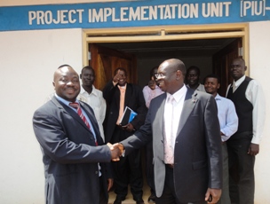 Boutros Magaya, Western Equatoria State Minister of Physical Infrastructure and Anthony Lino Makana, South Sudan Minister of Transport and Roads shake hands in Nzara as former CIVICOM compound is handed over to state authorities. Nov. 15, 2010 (ST)
