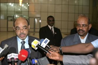 Sudanese President Omer Al-Bashir (R) listens on as Ethiopian President Meles Zenawi speaks to the press at Khartoum Airport on 19 Sept 2010 (Getty)