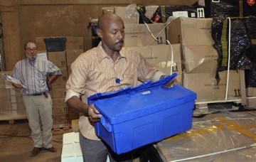 A Sudanese worker handles referendum materials procured by the United Nations Development Programme (UNDP) and the International Foundation for Electoral Systems (IFES), acting under a contract for the United States Agency for International Development (USAID), which were handed over to Southern Sudanese authorities Saturday, Oct. 30, 2010 in Khartoum, Sudan (AP)