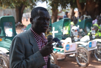 WES Governor Col Bangasi Joseph Bakosoro addressing motorbike ambulance launch in Yambio standing next to the motorbike ambulances on 29 Nov 2010 (ST)