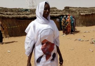 A female election worker wears an outfit with a picture of Sudanese president Omer Hassan al-Bashir at a polling station in the Darfur refugee camp of Abou Shouk on 11 April 2010 (AP)