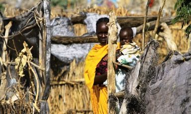 A woman holds her child in from of a shelter at the Kalma IDP camp outside Nyala in South Darfur on 29 November 2010 (Photo: Reuters)