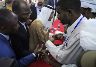 Djibril Bassole (2nd L) and Ahmed Bin Abdullah Al-Mahmoud (C) talk with protesters as they disrupt a meeting at the UN Compound in Nyala Nov 30, 2010. (Reuters)