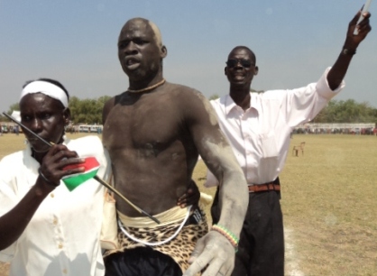 Bor wrestler, Deng Mawel, celebrates with relatives in Juba stadium on after defeating a rival. Dec. 11, 2010 (ST)