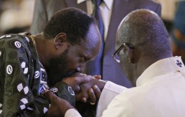 South Sudan's President Salva Kiir kisses a hand of the Roman Catholic Archbishop Paolino Lukudu Loro during a Christmas mass in St. Teresa's Cathedral in Juba December 25, 2010. (Reuters)
