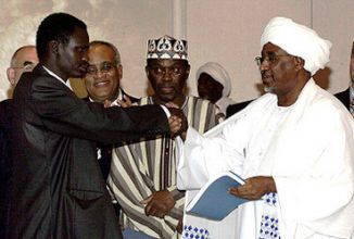 Mazjoud Al-Khalifa (R), who was in charge of Darfur file exchanges the African Union Peace agreement for Darfur with Minni Minawi, in Abuja on May 5, 2006 (AFP)