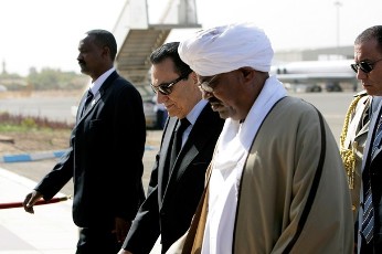 Sudanese President Omar al-Bashir (R) welcomes Egyptian President Hosni Mubarak (C) at Khartoum airport upon his arrival with Libyan leader Moamer Kadhafi (not in picture) on December 21, 2010 for talks with Bashir, ahead of a referendum on southern independence (AFP)