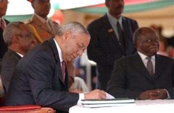 Gen Powell signs the CPA in Nairobi on Jan 9, 2005 as SVP Taha sits behind him