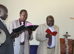 Lakes State governor Chol Tong Mayay holding the red Bible with and government advsior David Nok Marial (center) and SPLM state secretary Samuel Mathiang (left) attending church in Pacong. Dec 26, 2010 (ST)