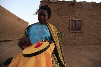 A Southern Sudanese woman who decided to stay in north Sudan does needlework at the Hadj Hassan district in south Khartoum January 6, 2011 (Reuters)