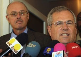 Dane Smith (L) appears behind Scott Gration speaking to reporters on 13 Jan 2011 in Khartoum (Reuters)