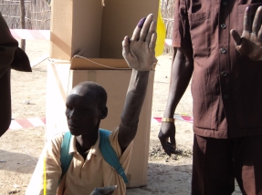 Gai Chang Keah, who is blind, gives the voting symbol for separation of the south after voting in Dare polling center in Bentiu, Unity state. Jan 9, 2011 (ST)