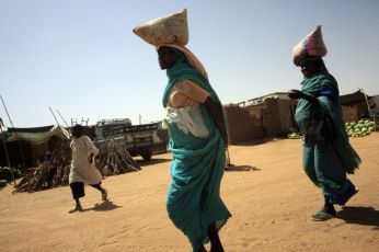 Internally displaced women carry food to their shelter at Alsalam camp - ElFasher 7 Nov 2010 (Reuters)