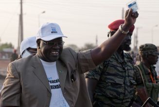 Riek Machar holds his voting card in his hand as he walks towards a polling station in Bentiu on Jan 9, 2011 (Getty)