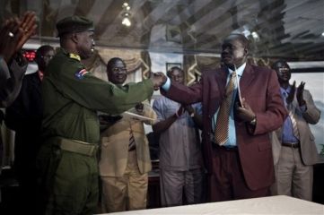 Senior SPLA, Brig. Gen. Michael Majur, left, shakes hands with Abraham Thon, right, representative of southern rebel leader Lt. Gen. George Athor, after signing a ceasefire agreement in Juba, Jan. 5, 2011 (AP)