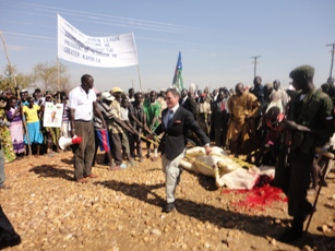 U.S. Ambassador to South Sudan Barrie R Walkley jumps over a sacrificed bull at the power plant opening in Kapoeta, E. Equatoria. Feb 4, 2011 (ST)