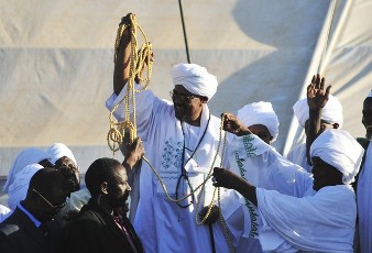 Sudan's President Omar Hassan al-Bashir holds up prayer beads as a gesture to supporters during a rally in northern Khartoum February 5, 2011 (Reuters)