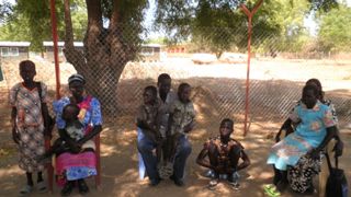 Atong Mac (left) sitting with her youngest son, Bior Malith and her daughter Nyibor on her right hand side. Majok Kelei (center) sitting with Leek and Garang on his lap. Abipini Ujulu with her mother Debora Amuor  outside the Bor county commmisioners office. Feb 5, 2011. (ST)