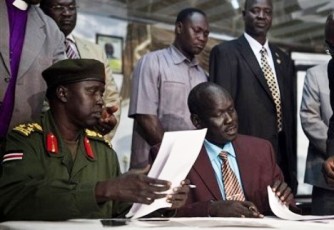 SPLA Brig. Gen. Michael Majur, left, and Abraham Thon, center, representative of southern rebel leader Lt. Gen. George Athor are seen at the signing of a ceasefire agreement in Juba, on Jan. 5, 2011. (AP)