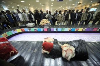 Sudanese evacuees who fled the unrest in Libya wait for their luggage after arriving at Khartoum airport February 28, 2011(Reuters Pictures)