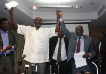 Azhary Shatta for LJM (L) and Ahmed Hussein Adam for JEM hold up a copy of the coordination agreement signed Tuesday 22 March in Doha (ST)