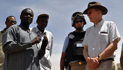 Ambassador Dane Smith (L) listening to a relief worker in Darfur during a recent visit to the region (photo US State Dept)