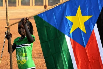 FILE - A girl holds a South Sudan flag during the announcement of the preliminary results of voting in Sudan, January 30, 2011 (Reuters)