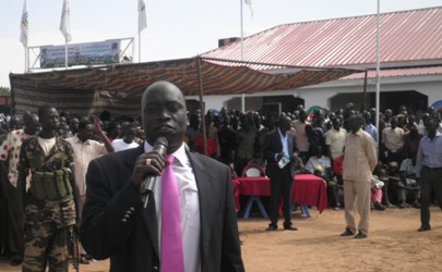 Deputy Governor Maar Nyuot addressing the gatherin as the South Sudan Hotel appears on the left (ST)