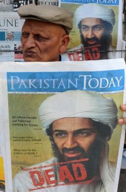 A Pakistani man reads a newspaper with the front page displaying news of the death of Osama bin Laden at a stall in Lahore on May 3, 2011. (Getty)