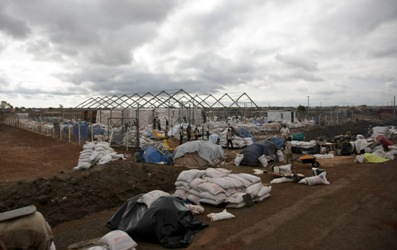 A photograph taken 24 May shows the World Food Programme compound in Abyei being looted by unidentified men and sacks of food lining the road for collection and transportation away. (Photo UNMIS/Stuart Price)