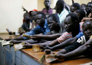 Traders jostle to change money in South Sudan (Reuters)