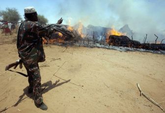 Villagers try to extinguish a fire in Kuma Garadayat, a village located in North Darfur (REUTERS PICTURES)