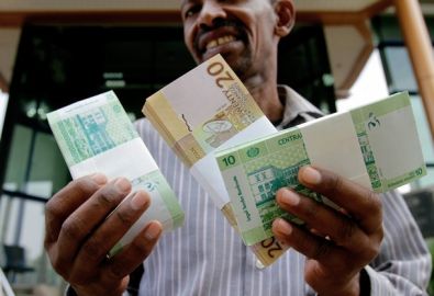 A Sudanese man shows freshly-minted notes of the new Sudanese pound in Khartoum on July 24, 2011 (Getty)