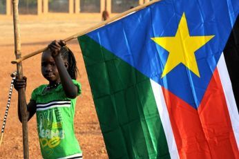 A girl holds a South Sudan flag during the announcement of the preliminary results of voting in Sudan, Jan 30, 2011 (Reuters)