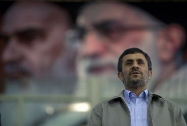 Iran's President Mahmoud Ahmadinejad stands for the national anthem beneath a portrait of Supreme Leader Ayatollah Ali Khamenei during a gathering of reformed drug addicts in Tehran June 26, 2011. (Reuters)
