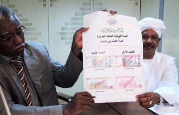 Sudan's Central Bank Deputy Governor Badr Al-Deen Mahmood holds up the new Sudanese currency during a news conference at the Central Bank headquarters in Khartoum July 16, 2011 (Reuters)