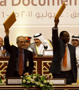 Sudan's Presidential Adviser Ghazi Salah Al-Deen Al-Attabani and Liberation Movement and Justice (LJM) representative Al-Tijani Al-Sissi (R) hold up the documents of a peace accord after the signing ceremony in Doha July 14, 2011 (UNAMID)