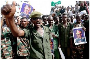 Sudanese soldiers shout slogans during the visit of President Omer al-Beshir (posters) to the town of Majlad in the south Kordofan province on May 20, 2009 (Getty Images)