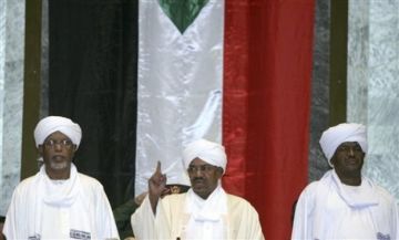 Sudanese President Omar al-Bashir, centre, gestures under a Sudanese flag as he arrives at the National Assembly in Khartoum, Sudan, Tuesday, July 12, 2011 (AP Photos)