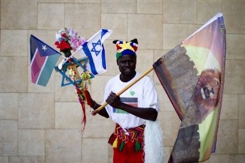 A Southern Sudanese man holds the flags of South Sudan and Israel during independence celebrations in Tel Aviv , Israel, Sunday, July 10, 2011 (AP)